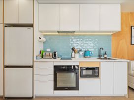 A kitchen with appliances and utensils at Opito Bay Holiday Home in Opito Bay