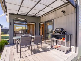 An outdoor patio with a table and chairs at Opito Bay Holiday Home, Opito Bay
