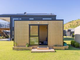 A small cabin structure with a door and window at Opito Bay Holiday Home Opito Bay