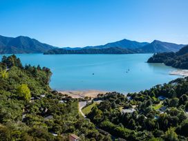 A scenic view of a bay with mountains and boats at Nature's Luxe - Moetapu Bay Holiday Home, Picton