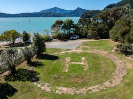 An aerial view of a helicopter landing area with trees and a lake at Nature's Luxe - Moetapu Bay Holiday Home in Picton