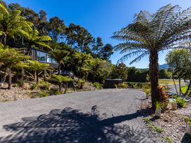 An outdoor area with a driveway and palm trees at Nature's Luxe - Moetapu Bay Holiday Home in Picton