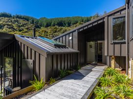 An outdoor view showing a building with a pathway and surrounding plants at Nature's Luxe - Moetapu Bay Holiday Home, Picton