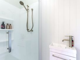 A bathroom with a shower and sink at Nature's Luxe - Moetapu Bay Holiday Home, Picton