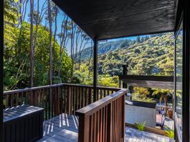 A balcony with outdoor furniture and views of trees and mountains at Nature's Luxe - Moetapu Bay Holiday Home, Picton