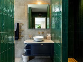 A bathroom with a sink and mirror at Nature's Luxe - Moetapu Bay Holiday Home, Picton