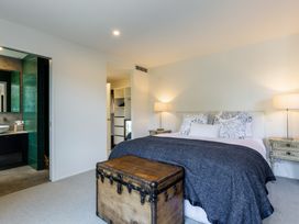 A bedroom with a bed and a chest at Nature's Luxe - Moetapu Bay Holiday Home Picton