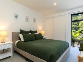 A bedroom with a bed and nightstand at Nature's Luxe - Moetapu Bay Holiday Home, Picton