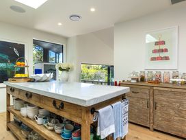 A kitchen with an island, fruit bowl, and storage cabinets at Nature's Luxe - Moetapu Bay Holiday Home, Picton