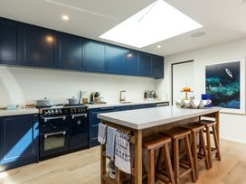 A kitchen with cabinets and an island at Nature's Luxe - Moetapu Bay Holiday Home in Picton
