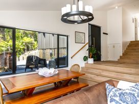 A dining room with a wooden table and staircase at Nature's Luxe - Moetapu Bay Holiday Home, Picton