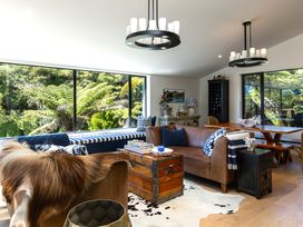 A living room with a sofa and dining area at Nature's Luxe - Moetapu Bay Holiday Home, Picton
