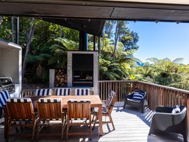 An outdoor patio with a dining table and chairs at Nature's Luxe - Moetapu Bay Holiday Home in Picton