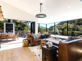 A living room with a sofa and dining table at Nature's Luxe - Moetapu Bay Holiday Home in Picton
