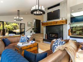 A living room with a sofa, coffee table, and fireplace at Nature's Luxe - Moetapu Bay Holiday Home, Picton
