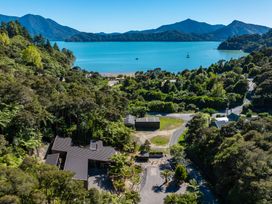 An aerial view of a house surrounded by trees and mountains at Nature's Luxe - Moetapu Bay Holiday Home Picton