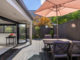 An outdoor patio with a table and chairs at Mount Maunganui