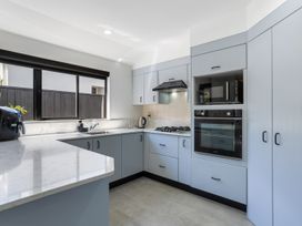A kitchen with cabinets, sink, and appliances at Mount Maunganui