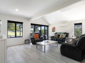 A living room with sofas and a table at Mount Maunganui
