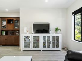 A living room with television and cabinets at Mount Maunganui