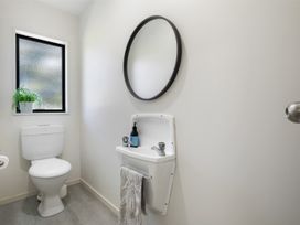A bathroom with a toilet and sink at Mount Maunganui