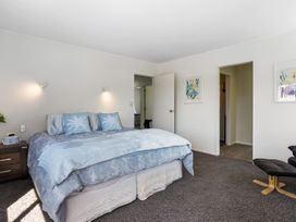 A bedroom with a bed and nightstand at Mount Maunganui