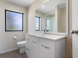 A bathroom with a sink, toilet, and shower at Mount Maunganui