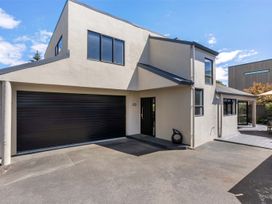 A house with a garage and patio at Mount Maunganui