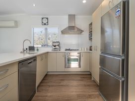 A kitchen with appliances and cabinetry at Ocean Haven - Whangamata Holiday home Whangamata