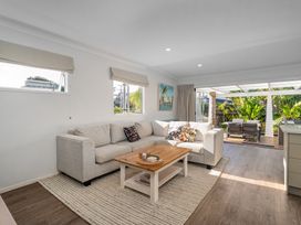 A living room with a sofa and coffee table at Ocean Haven - Whangamata Holiday home Whangamata