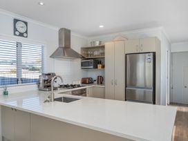 A kitchen with appliances including a refrigerator and gas stove at Ocean Haven - Whangamata Holiday home in Whangamata
