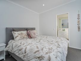 A bedroom with a bed and doorway at Ocean Haven - Whangamata Holiday home, Whangamata