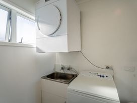 A laundry room with a washer and dryer at Ocean Haven - Whangamata Holiday home in Whangamata