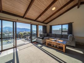 A living room with a sofa and coffee table at Four Peaks Matai Escape - Te Anau