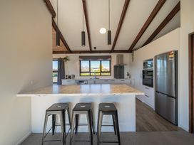 A kitchen with appliances and a bar area at Four Peaks Matai Escape - Te Anau