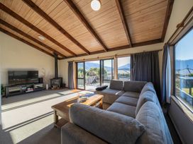 A living room with a sofa and television at Four Peaks Matai Escape - Te Anau