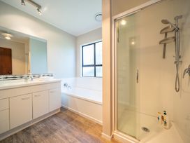 A bathroom with a bathtub, shower, and sink at Four Peaks Matai Escape - Te Anau