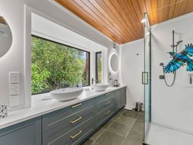 A bathroom with two basins and a glass shower at Camelot - Lake Taupo Holiday Home Turangi