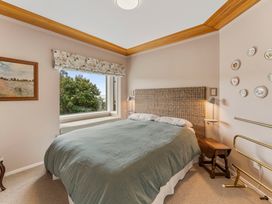 A bedroom with a bed and window at Camelot - Lake Taupo Holiday Home in Turangi