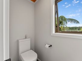 A bathroom with a toilet and a window at Camelot - Lake Taupo Holiday Home Turangi
