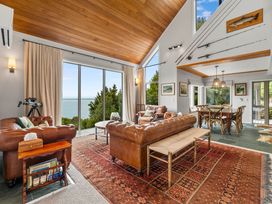 A living room with a sofa and dining table at Camelot - Lake Taupo Holiday Home Turangi