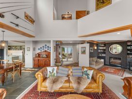 A living room with a sofa and dining table at Camelot - Lake Taupo Holiday Home in Turangi