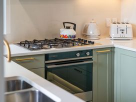 A kitchen with an oven, stove, kettle, and toaster at Camelot - Lake Taupo Holiday Home in Turangi