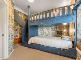 A bedroom with a bunk bed and decorative wall at Camelot - Lake Taupo Holiday Home in Turangi