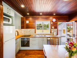 A kitchen with appliances and a dining table at Pacific Vista - Hawkes Bay Havelock North