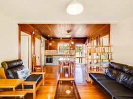 A living room with a sofa, coffee table, and bookshelf at Pacific Vista - Hawkes Bay Havelock North