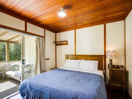 A bedroom with a bed and sliding door at Pacific Vista - Hawkes Bay Havelock North
