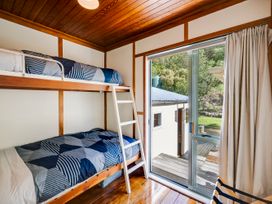 A bedroom with bunk beds and a sliding door at Pacific Vista - Hawkes Bay Havelock North