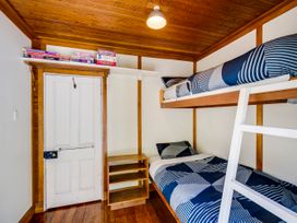 A bedroom with a bunk bed and single bed at Pacific Vista - Hawkes Bay Havelock North