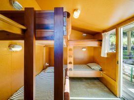 Bunk beds with striped bedding in a bedroom at Pacific Vista - Hawkes Bay Havelock North